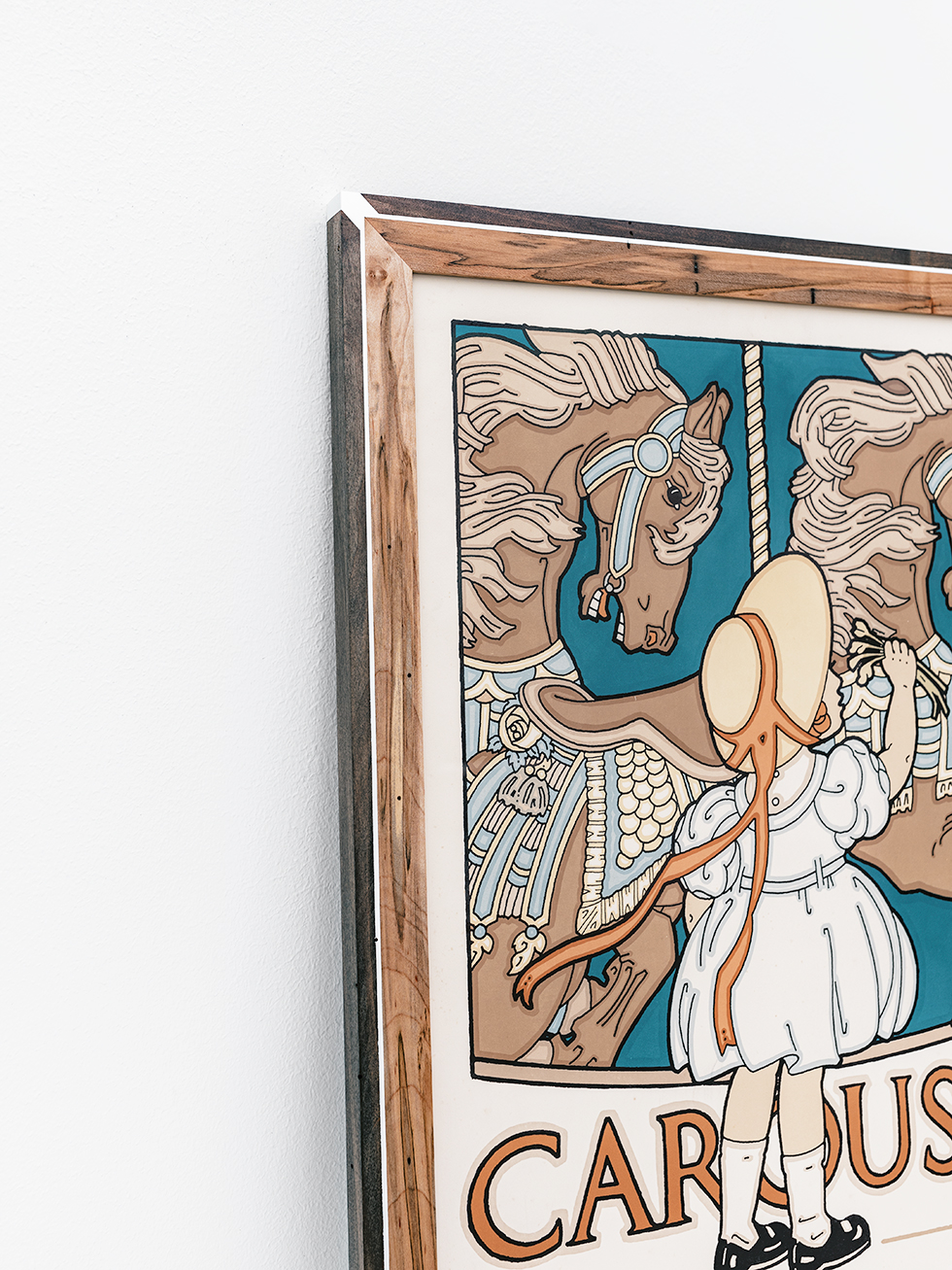 Detail view of the custom painted details on the figured maple wood frame for the vintage David Lance Goines Carousel poster.