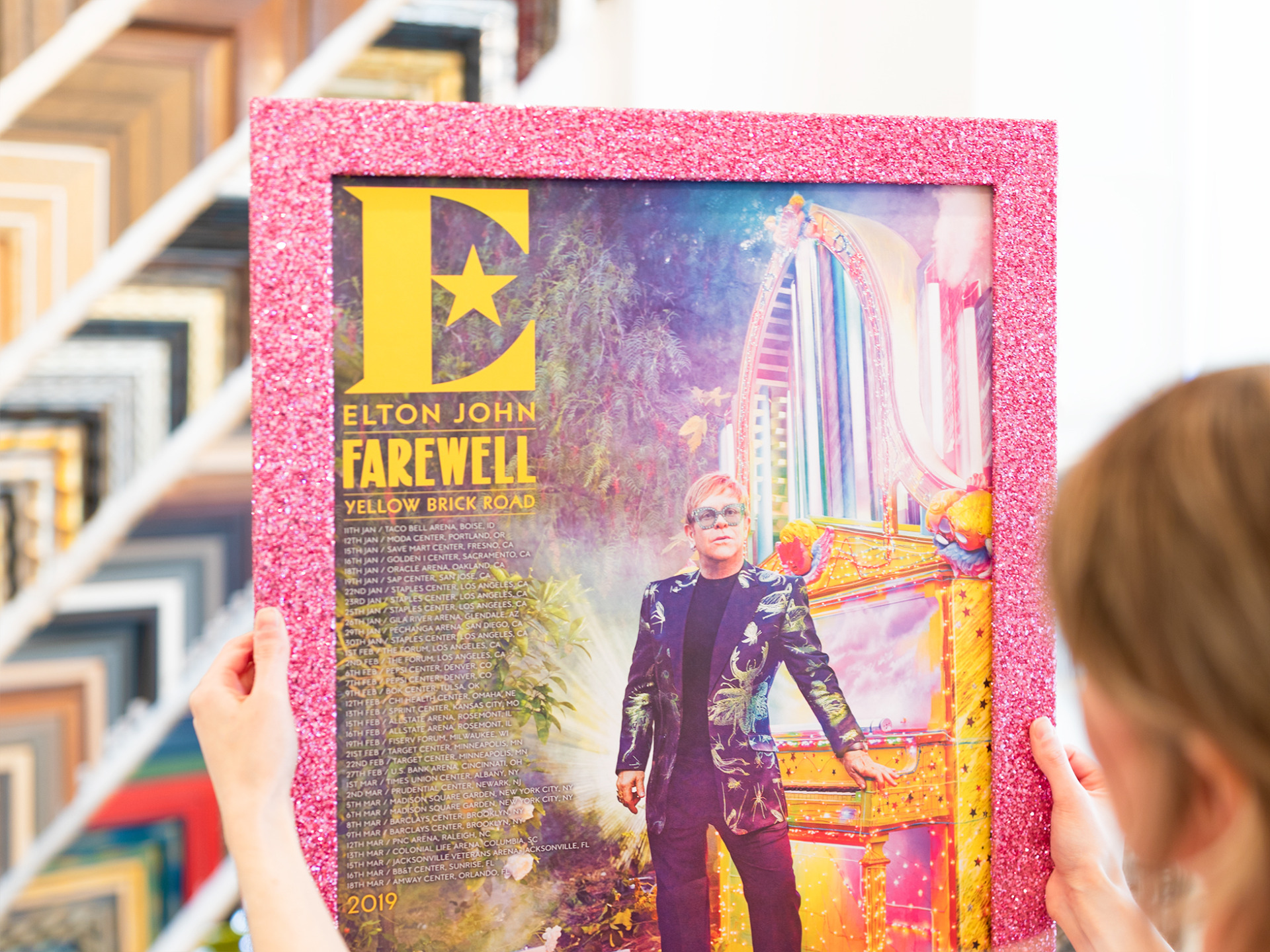 Elton John Farewell concert poster framed in a pink glitter frame.