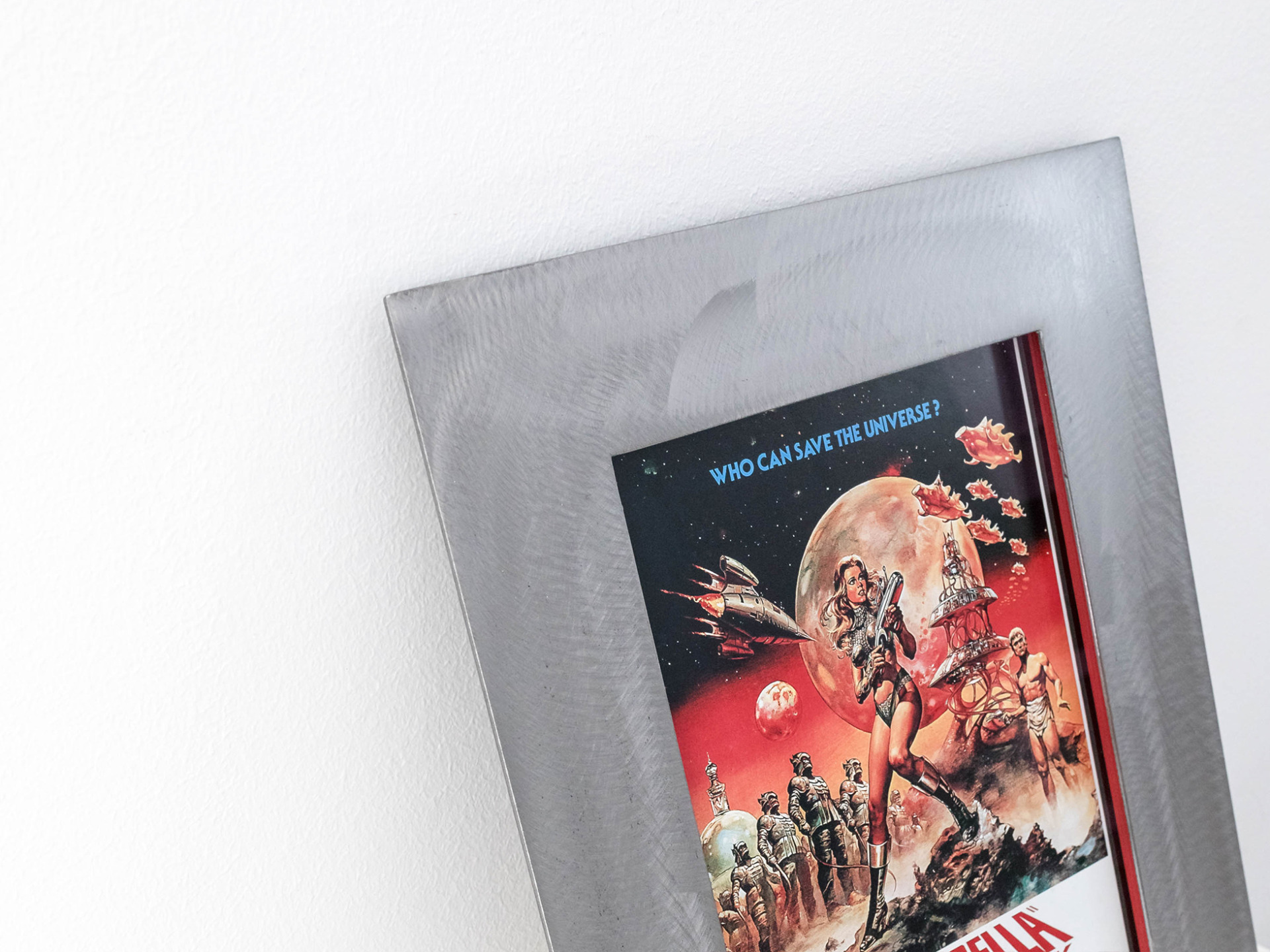 Details of a Barbarella movie poster framed in a wide, welded steel custom frame.