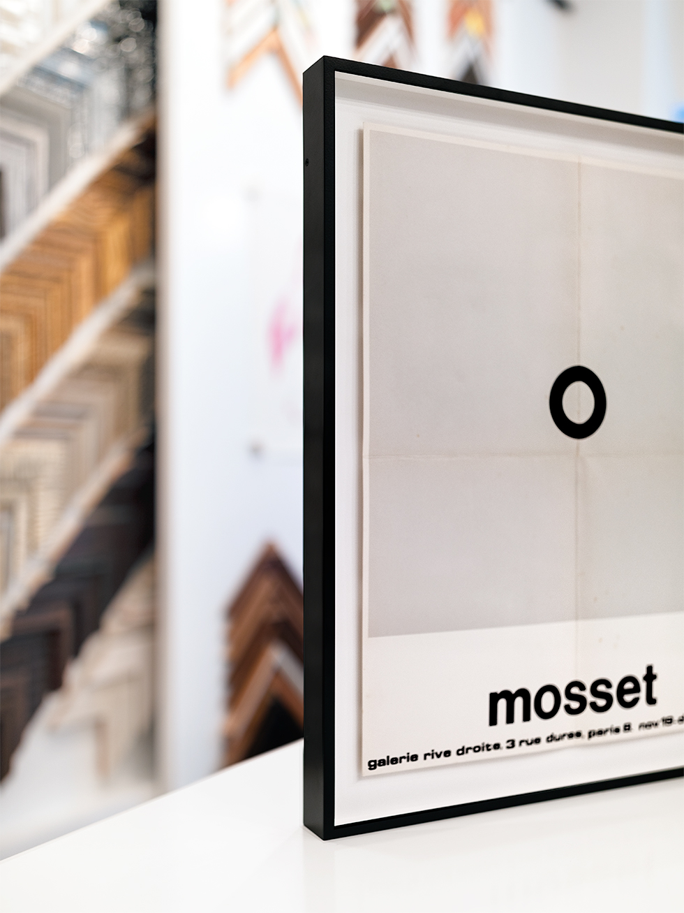 Details of a vintage Mosset poster float mounted in a thin, welded aluminum black frame.