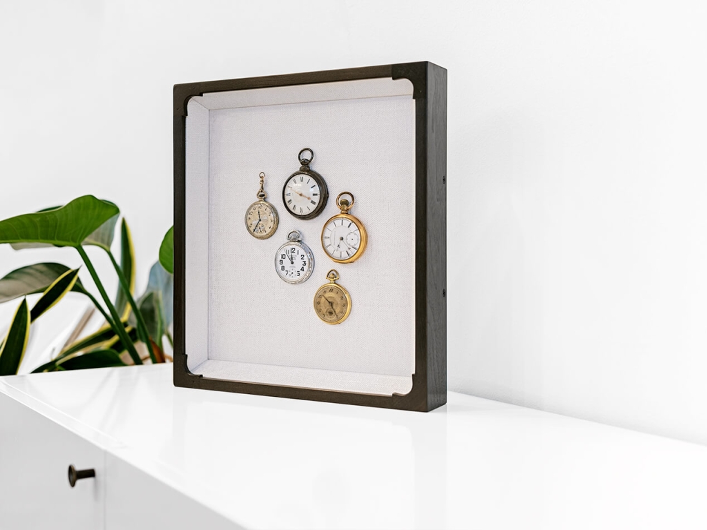 Custom framing of shadow box with pocket watch collection